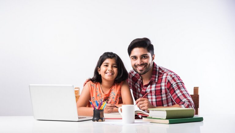 Cute Indian girl with father studying or doing homework at home using laptop and books